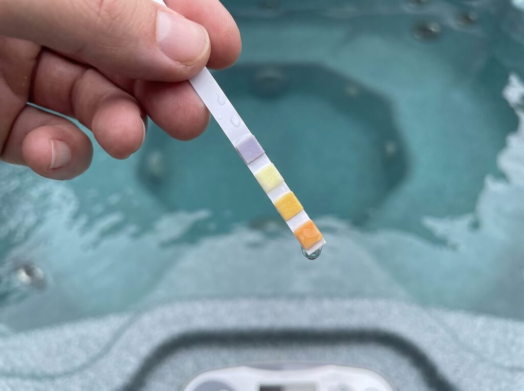 test strip pad reading calcium hardness beside hot tub water