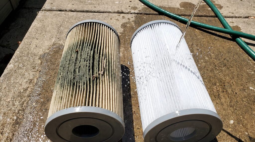dirty green-stained spa filter beside a clean one being rinsed with a hose