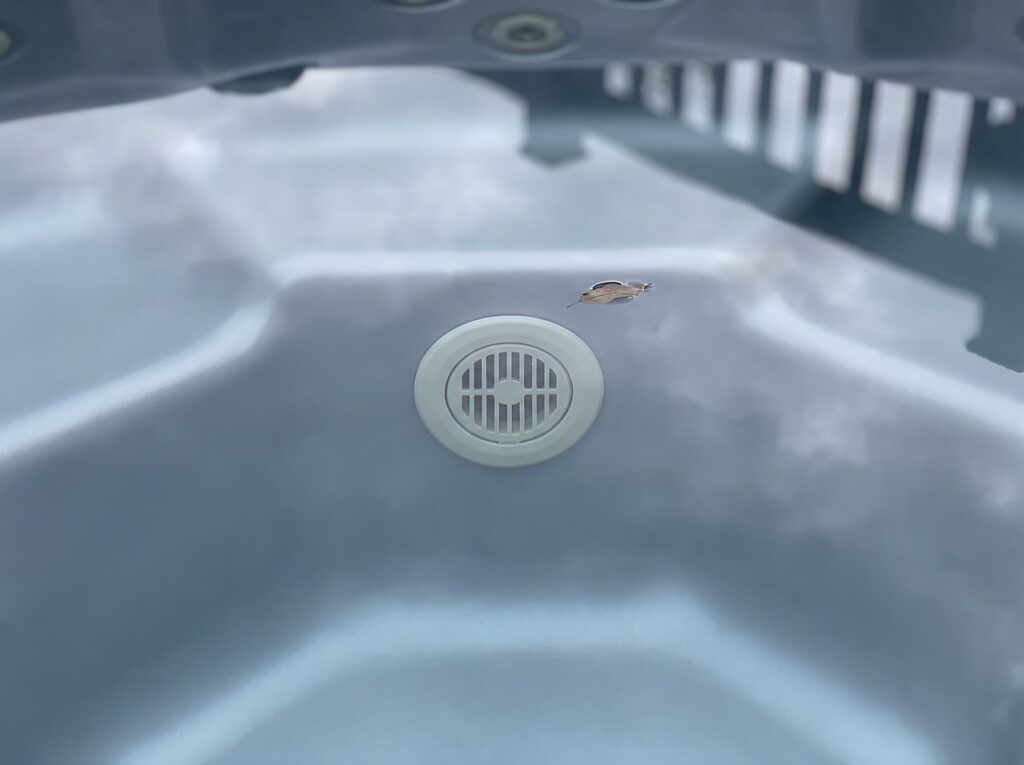 still water above a hot tub return fitting showing no outward flow ripple