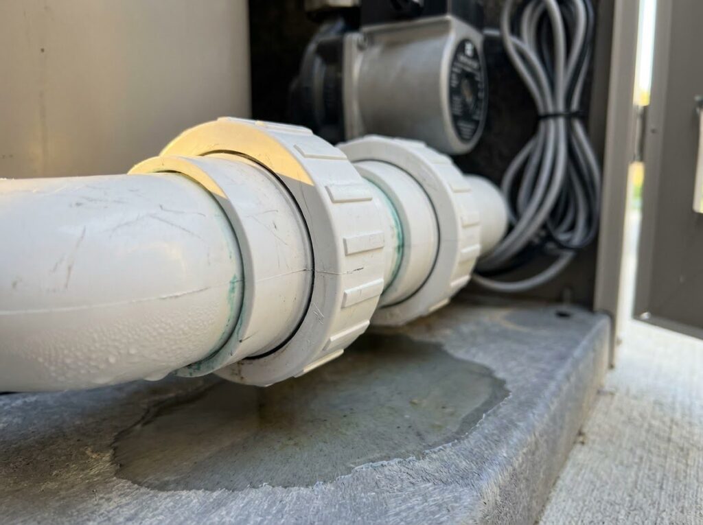 close-up of plastic union fittings and O-ring seams on a spa heater pipe