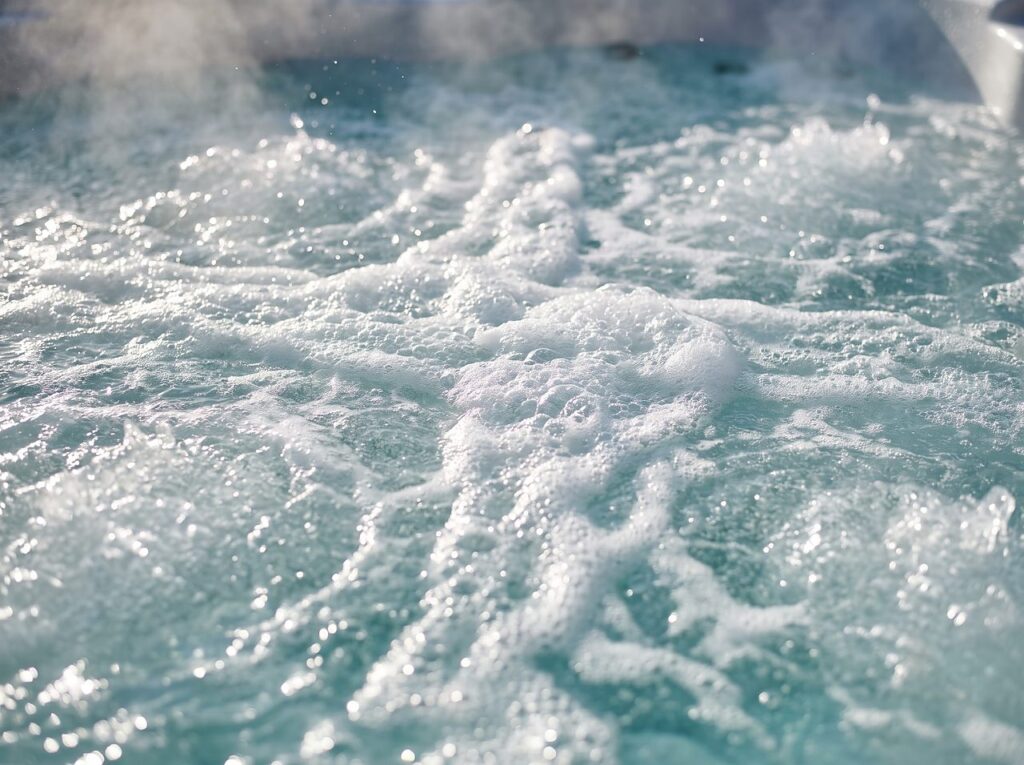dense bubbles churning across a hot tub's water surface from underwater jets