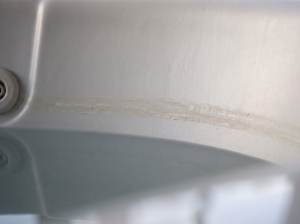 thin scum ring at a hot tub's waterline showing buildup between water changes