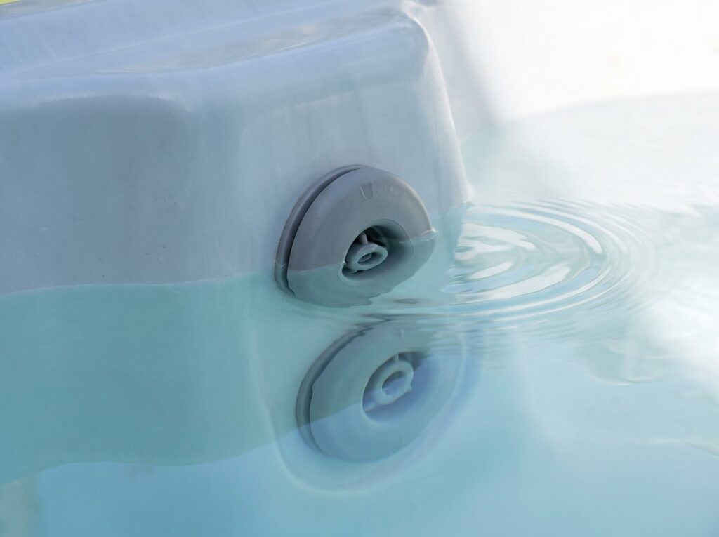 hot tub jet fitting fully submerged as fill water rises past the waterline